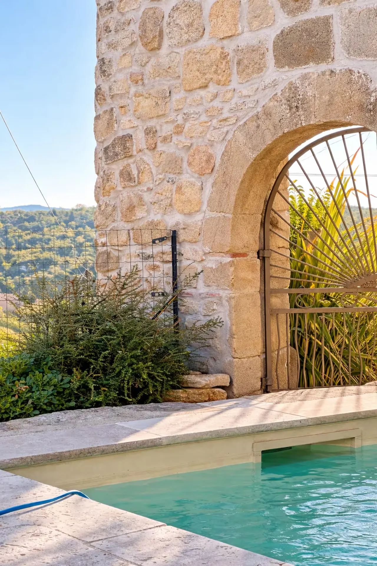 Arche en pierre et piscine avec vue sur les collines